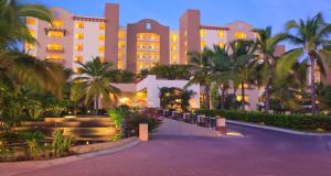 Un gran edificio con palmeras delante. en 2BD Oceanview Suite Villa del Palmar Flamingos, en Nuevo Vallarta 