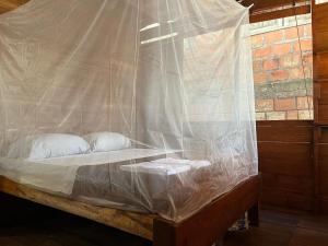 a bed covered in a net with two pillows at Renacer in Termales - agua caliente - nuqui