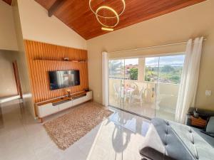 a living room with a flat screen tv and a couch at Casa Superior Pedro Tavares in Búzios