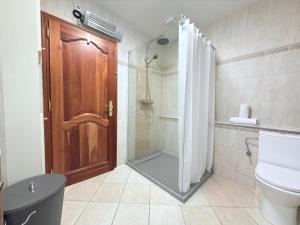 a bathroom with a shower and a toilet and a door at Beautiful house with garden, game, gym, terrace&parking in Strassen +23 photos