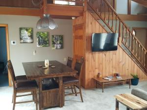 a dining room with a wooden table and a tv at Woodland Hideaway in Naples
