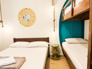 南圣弗朗西斯科Babitonga Hostel - 100m da Prainha的一间卧室，墙上有两张床和一面镜子