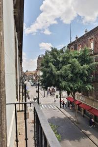 een balkon met uitzicht op een stadsstraat bij CASA SAUTO Historic Fam Suite 1 block from Zocalo in Mexico-Stad +31 foto's