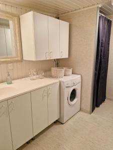 a kitchen with a washing machine and a sink at Stugan Hultet in Hjälteby +27 photos