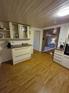 cocina con armarios blancos y suelo de madera en Stugan Hultet, en Hjälteby