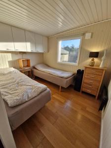 a bedroom with two beds and a window at Stugan Hultet in Hjälteby