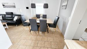 Un comedor con una mesa y sillas negras. en Ferienhaus Angela Kellenhusen - 6 Personen 3 Schlafzimmer 4, en Kellenhusen