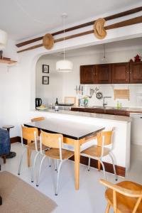 a kitchen with a table and chairs in a room at 2-bedroom house w garden in heart of Ferragudo village in Ferragudo