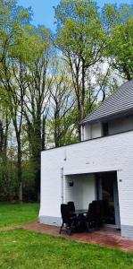 een wit gebouw met een tafel en stoelen erin bij Vakantiebungalow BERK 1 in Aan de Wolfsberg