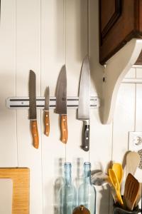 a bunch of knives hanging on a kitchen wall at 2-bedroom house w garden in heart of Ferragudo village in Ferragudo