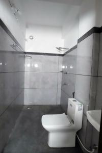 a bathroom with a white toilet and a sink at bethel apartments teekoy in Erāttupetta