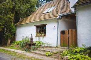 a small white house with a window and a door at Tömördi Vendégház in Tömörd
