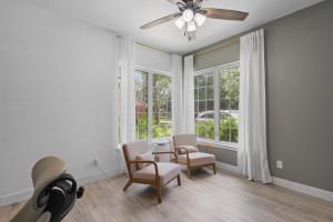 a living room with a table and chairs and windows at Woodbridge Bungalow - Private Villa Near IAH - Pool in Houston