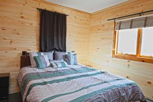 a bedroom with a bed in a log cabin at Private Hot tub new 2 Bedroom Home in Catskills in Elka Park