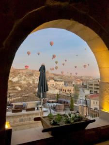 a view of hot air balloons in the sky from a building at Kismet Cave Mansion in Göreme +97 photos