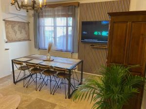 a dining room with a table and chairs and a tv at Le Clos des Papes in Avignon