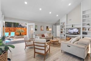 a living room with white furniture and a large window at Woodbridge Bungalow - Private Villa Near IAH - Pool in Houston