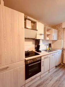 a kitchen with white cabinets and a stove top oven at Apartment Fürstenau 5P Küche in Fürstenau