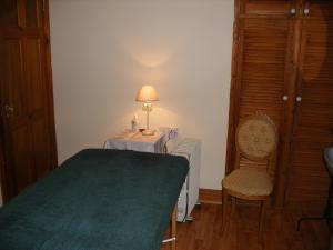 a bedroom with a table with a lamp and a chair at Mountshannon cottage in Mountshannon