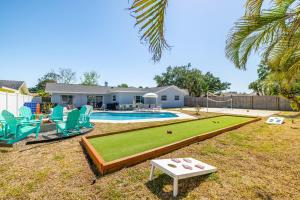 a backyard with a pool with chairs and a table at Backyard Oasis w Sand Volleyball Mins to Beach in Seminole