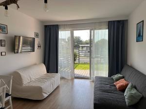 a living room with a couch and a sliding glass door at Seaside Chill in Mechelinki