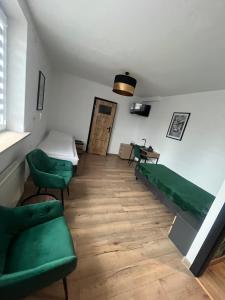 a living room with green chairs and a couch at Happy 4 in Krosno
