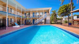 a swimming pool in front of a building at Coasters 2 in Sawtell