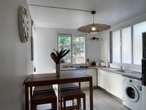 a kitchen with a table and chairs and a sink at Tibo bas de villa NEUF accès mer in Deshaies