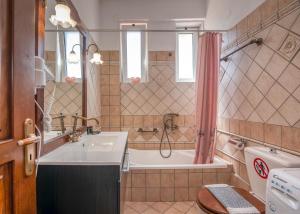 a bathroom with a sink and a tub and a toilet at Achilleas Deluxe House-Jacuzzi - BBQ in Kotsianá +28 photos