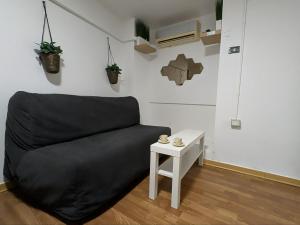 Cozy Loft in Historical Center في جينوا: أريكة سوداء في غرفة مع طاولة