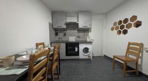 Cozy Loft in Historical Center في جينوا: مطبخ مع طاولة وكراسي وغسالة ملابس