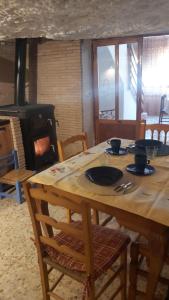 a wooden table with chairs and a wood stove at Gaiamoment La casa la panadera in Alcalá del Júcar