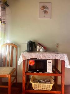 a table with a microwave on a table with a chair at Habitación con baño privado in Sucre