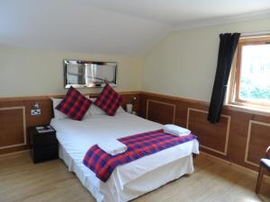 1 dormitorio con 1 cama con manta a cuadros en Bala House, en Edimburgo