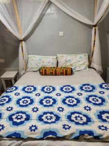 a bed in a tent with a blue and white comforter at Mizpah House in Kikuyu