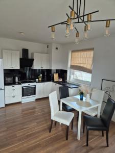una cucina con tavolo e sedie e una sala da pranzo di Apartament Słoneczny Taras przy Aquapark Reda a Rumia