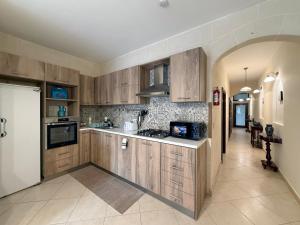 a large kitchen with wooden cabinets and a hallway at Seashell Stories - Modern Comforts, Traditional Charm in Nadur