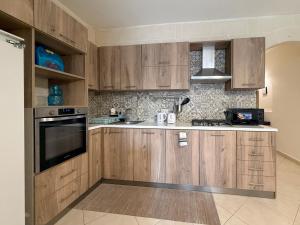 a kitchen with wooden cabinets and a stove top oven at Seashell Stories - Modern Comforts, Traditional Charm in Nadur