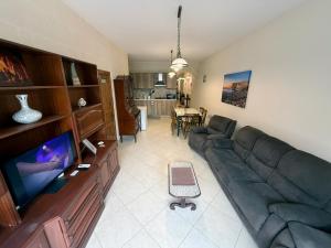a living room with a couch and a television at Seashell Stories - Modern Comforts, Traditional Charm in Nadur