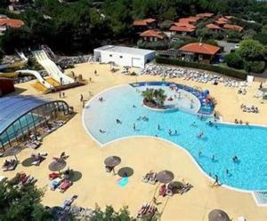 米尼赞海滩KOKUA VACANCES Mobil Homes Résidentiels camping 4 étoiles MIMIZAN PLAGE的俯瞰一座大型游泳池，里面有人