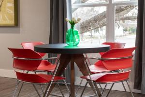 a table with red chairs and a green vase with flowers at Plaza Pad II-Near Plaza District in Oklahoma City