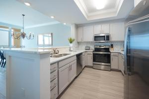 a kitchen with white cabinets and stainless steel appliances at Phoenix Gulf Towers 806 condo in Gulf Shores