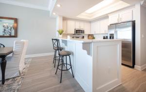 a kitchen with white cabinets and a table and chairs at Phoenix Gulf Towers 806 condo in Gulf Shores