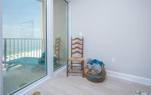 a room with a chair and a bench on a balcony at Phoenix Gulf Towers 806 condo in Gulf Shores
