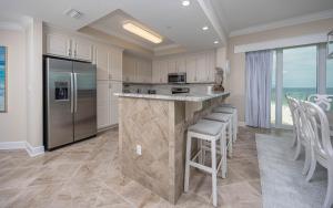 a kitchen with a large island with bar stools at Phoenix Gulf Towers 1008 condo in Gulf Shores