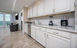 a kitchen with white cabinets and a counter top at Phoenix Gulf Towers 1008 condo in Gulf Shores