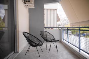 2 sillas sentadas en un balcón con ventana en Luxury Lounge Apartment, en Tríkala