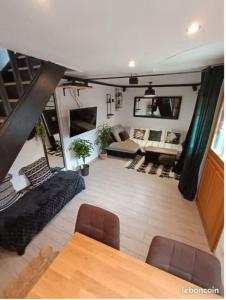 a living room with a table and a couch at Maison à colombage dans cour privée avec jardin sur les remparts du village in Bergheim
