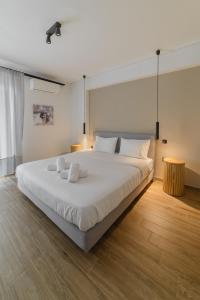 Un dormitorio con una gran cama blanca con almohadas blancas. en Luxury Lounge Apartment, en Tríkala