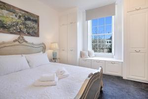 a bedroom with a bed with a towel on it at Silver Street Townhouse - Grampian Lettings in Aberdeen